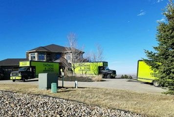 A large house with two trucks parked in front of it.