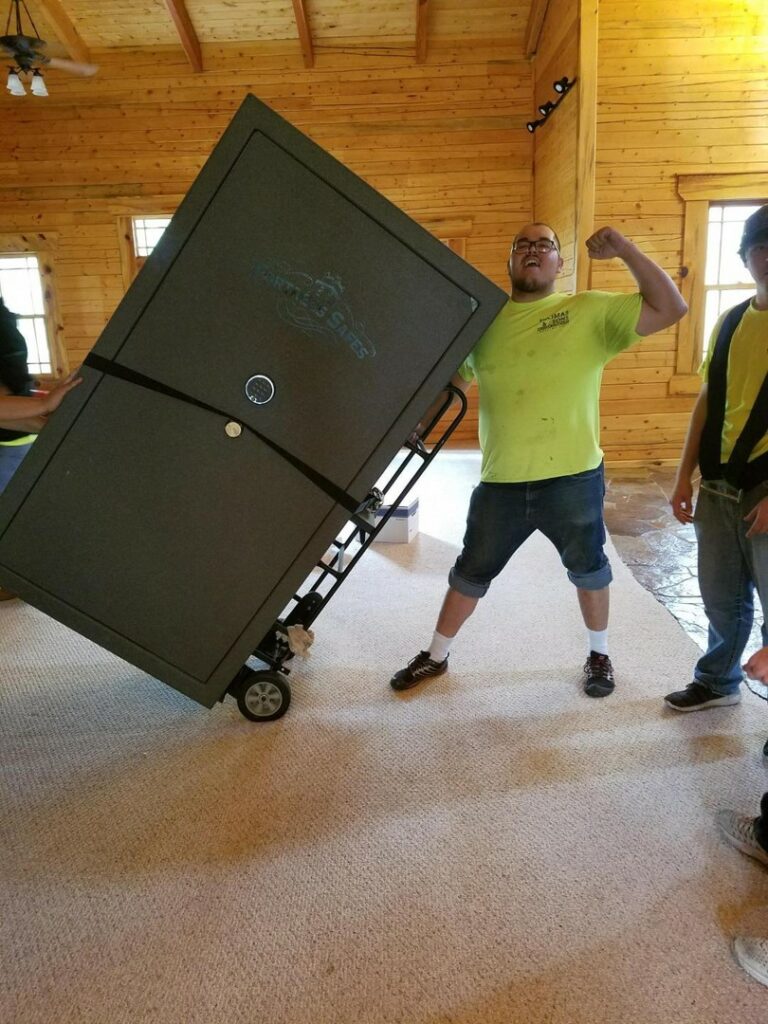 A man in yellow shirt lifting a black box.