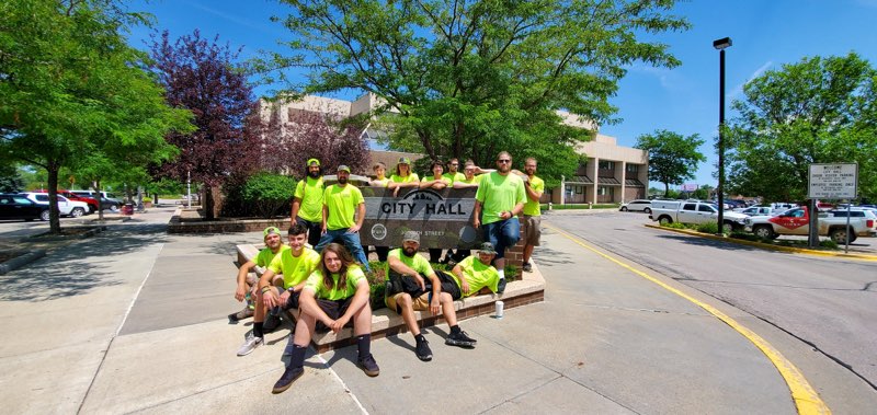 A group of people in yellow shirts and jeans posing for the camera.