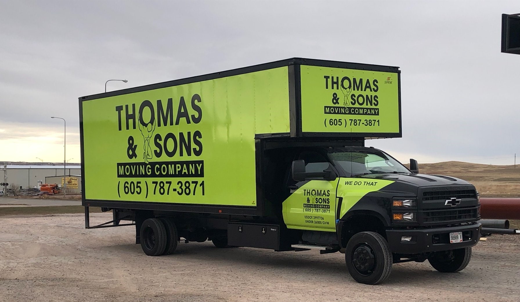 A truck with the thomas and sons moving company logo on it.