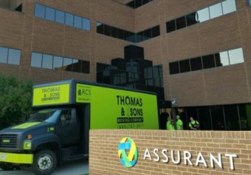 A truck parked in front of an office building.